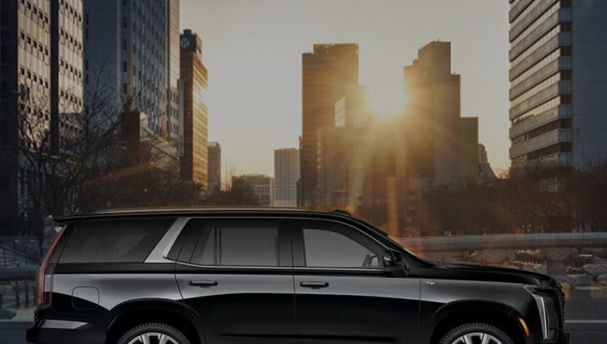 Black Cadillac Escalade on a city street at sunrise